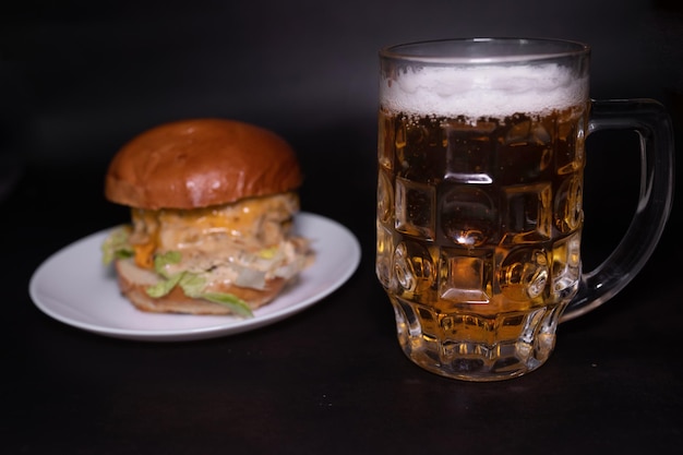 Ein Glas Bier neben einem Burger mit einem Bier darin.