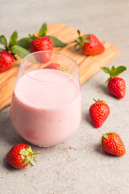 Ein Glas frischen Erdbeermilchshake auf rosa Hintergrund