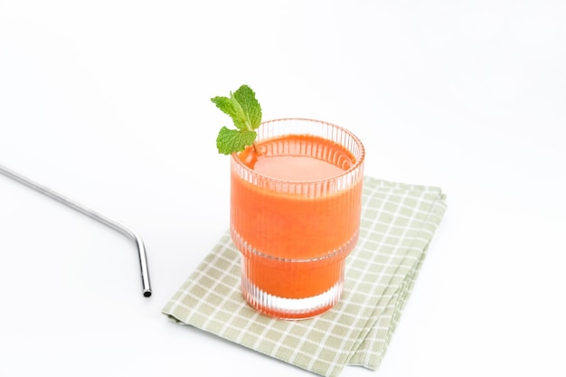 Ein Glas frischer Karottensaft, sehr gut für die Gesundheit. Serviert im Glas auf weißem Hintergrund