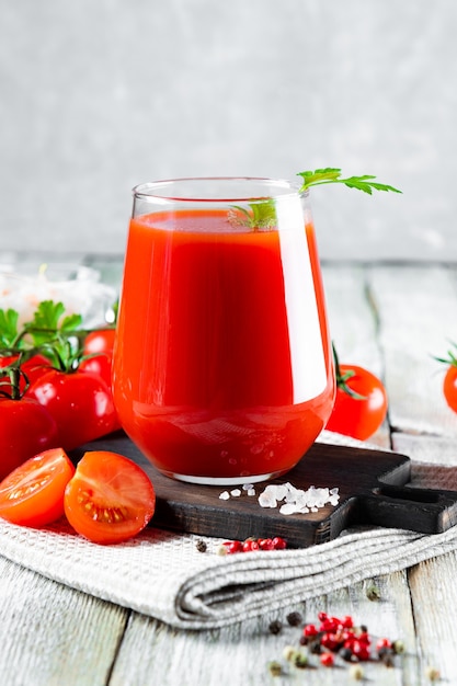 Ein Glas frischer Tomatensaft hautnah auf dem Tisch.