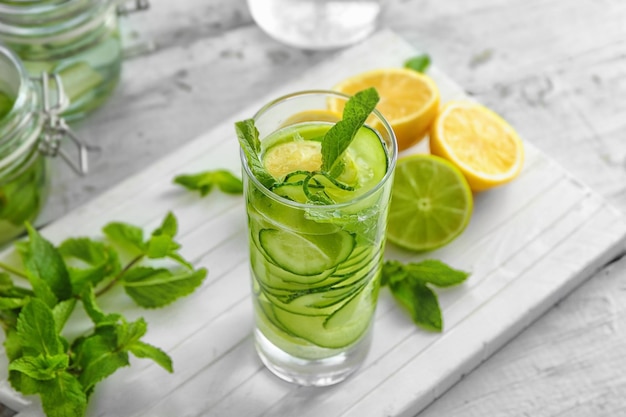 Ein Glas frisches Gurkenwasser mit Zitrone und Minze auf dem Tisch