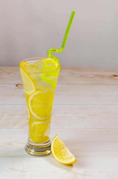 Foto ein glas gekühltes limonaden-eiswasser und zitronen-erfrischungsgetränk und zitrone auf einem holzhintergrund