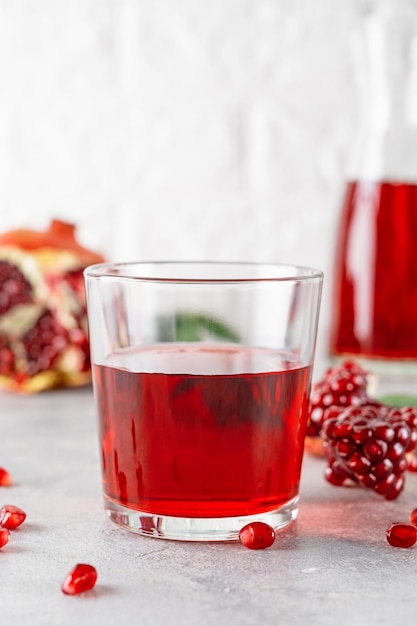 Ein Glas Granatapfelsaft mit frischen Granatapfelfrüchten. Gesundes Getränkekonzept