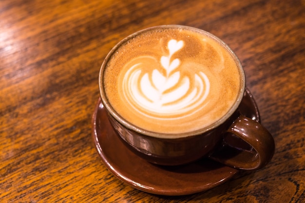 Ein Glas Kaffee. Latte-Kunstkaffee auf hölzernem Tabellenhintergrund