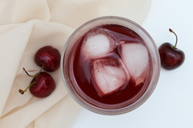 Ein Glas Kirschsaft mit Eiswürfeln darauf