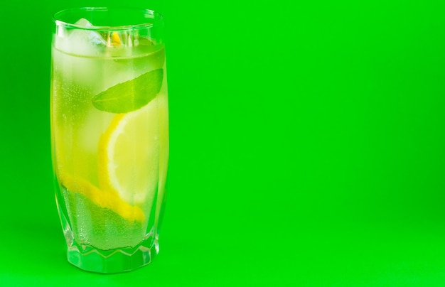 Ein Glas Limonade mit Minze auf hellgrünem Hintergrund Cooling Drink SummerCopy Space