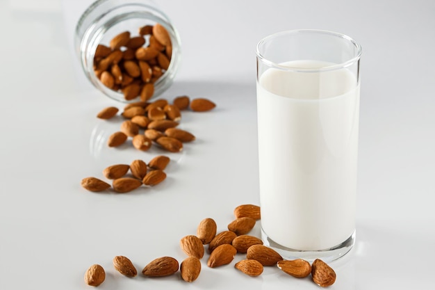 Ein Glas Mandelmilch auf weißem Hintergrund Laktosefreie pflanzliche Diätmilch