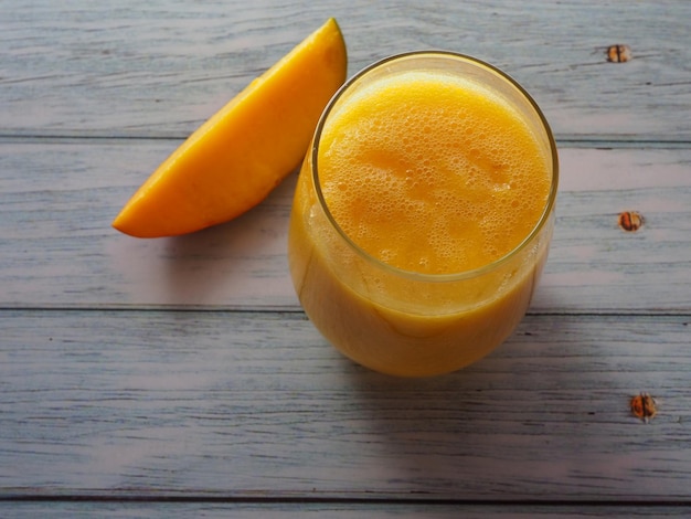 Ein Glas Mangosaft auf einem Holztisch