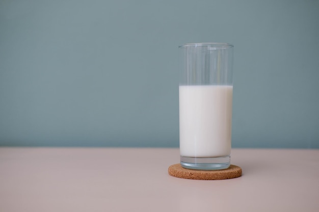 Ein Glas Milch auf Holztisch im grünen Hintergrund