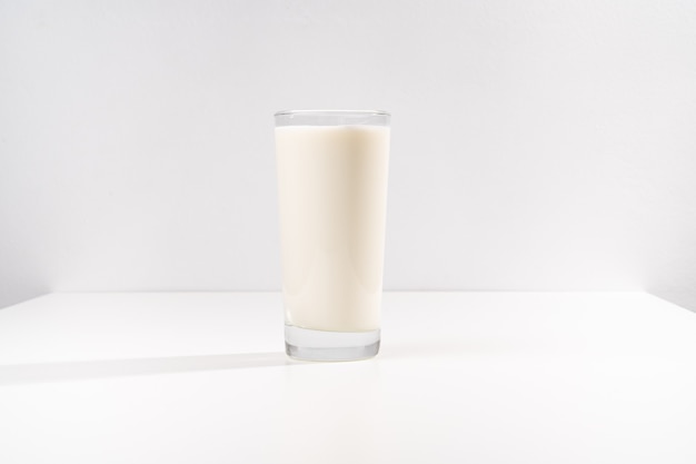 Ein Glas Milch auf weißem Hintergrund. Verkauf von landwirtschaftlichen Produkten.