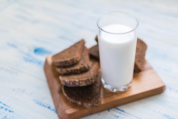 Ein Glas Milchkefir und eine Scheibe Schwarzbrot auf Holzhintergrund Das Konzept der gesunden Ernährung