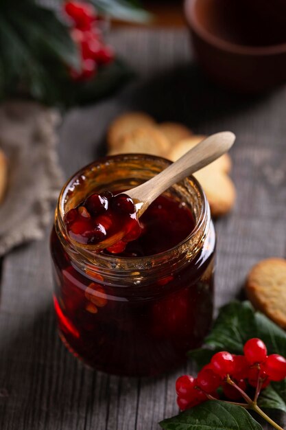 Ein Glas mit einem Holzlöffel für Beerenmarmelade darauf