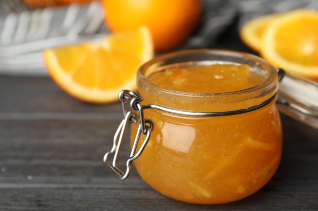 Ein Glas Orangenmarmelade auf einem grauen Holztisch