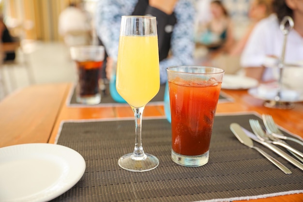 Ein Glas Orangensaft und ein Getränk auf einem Tisch.