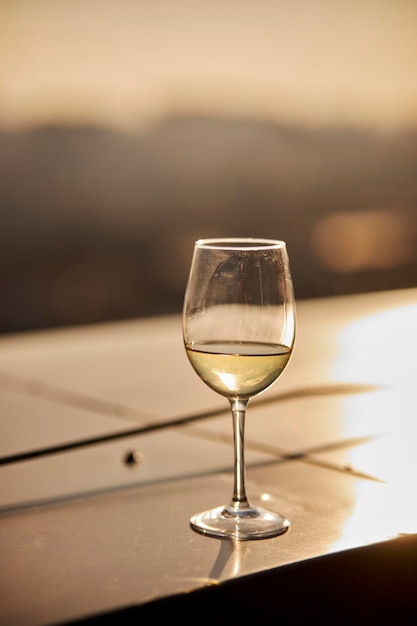 Ein Glas prickelnder Champagner steht bei Sonnenuntergang im Sommer auf einem Tisch in einem Restaurant