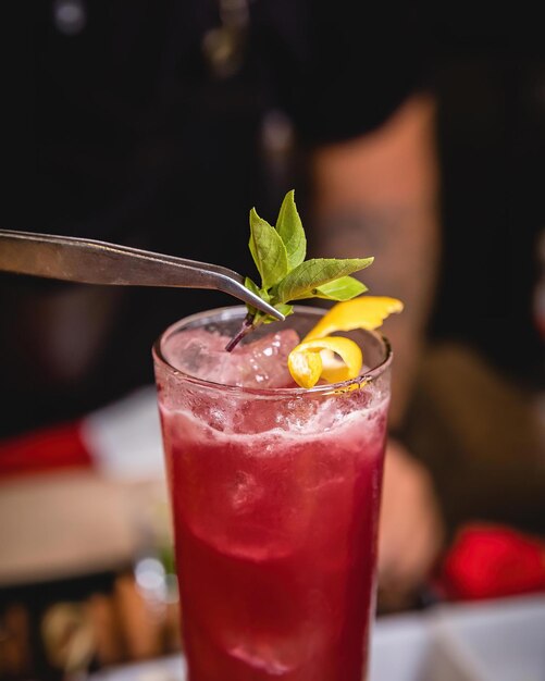 Ein Glas roter Cocktail mit einer Zitrone am Rand