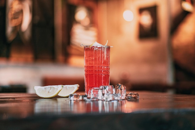 Foto ein glas roter cocktail mit einer zitronenscheibe als beilage.