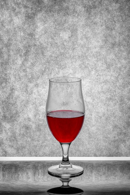 Foto ein glas rotwein auf einem grauen hintergrund