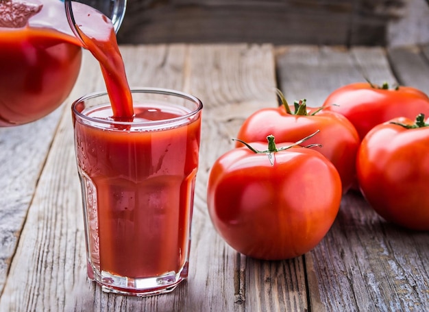 Ein Glas Tomatensaft wird in ein Glas gegossen.