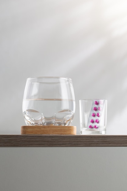 Ein Glas Wasser und Medizin auf dem Holztisch