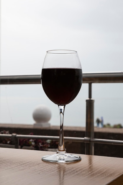 Ein Glas Wein auf dem Tisch im Café vor dem Hintergrund des Fensters