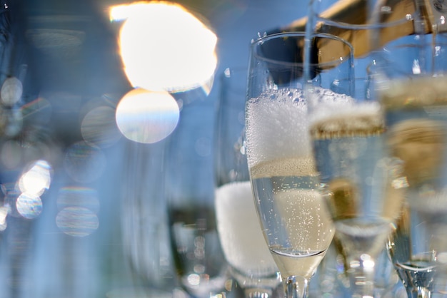 Ein Glas Wein mit Flasche gießt Champagner. Foto in hoher Qualität