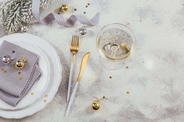 Ein Glas weißer Sekt oder Champagner und Neujahrsdekoration auf hellem Hintergrund. Winterferien-Konzept.