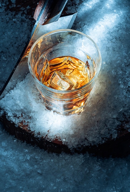 Foto ein glas whiskey im schnee konzept eines wärmenden getränks an einem kalten winterabend