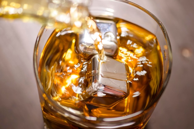 Foto ein glas whiskey mit eiswürfel auf holztisch