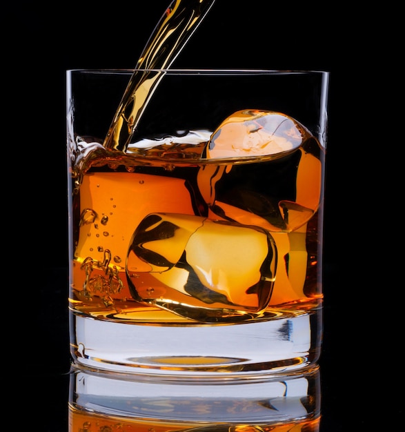 Ein Glas Whiskey und Eis auf schwarzem Hintergrund