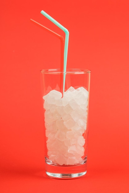 Ein Glas Zuckerwürfel ist ein Konzept ungesunder Lebensmittel auf rotem Hintergrund