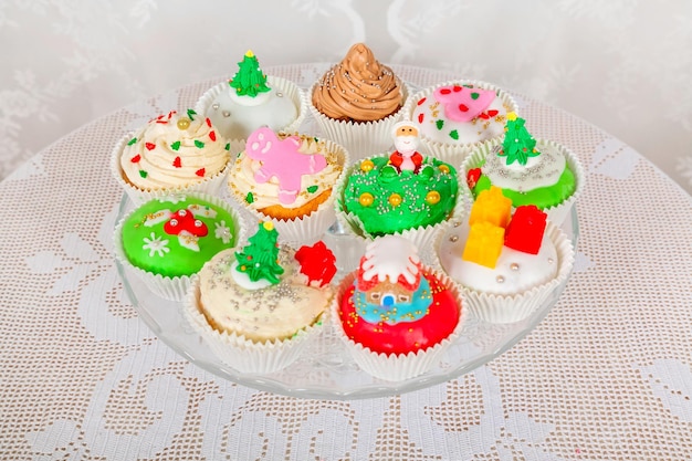 Ein Glasständer mit hausgemachten Kuchen, Cupcakes, Muffins im weihnachtlichen Stil dekoriert.