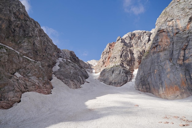 Foto ein gletscher liegt in einer felsigen schlucht, die im sommer von der mittagssonne beleuchtet wird