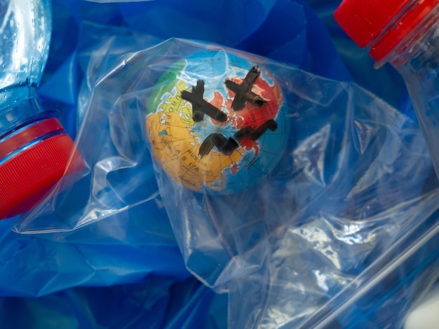 Ein Globus in einer Plastiktüte in einem Haufen Plastikmüll