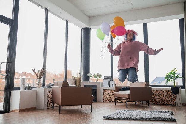 Ein glücklich lächelndes junges Mädchen mit einem Haufen Luftballons