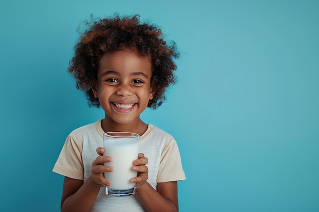 Ein glücklicher afroamerikanischer kleiner Junge mit einem Glas Milch auf blauem Hintergrund