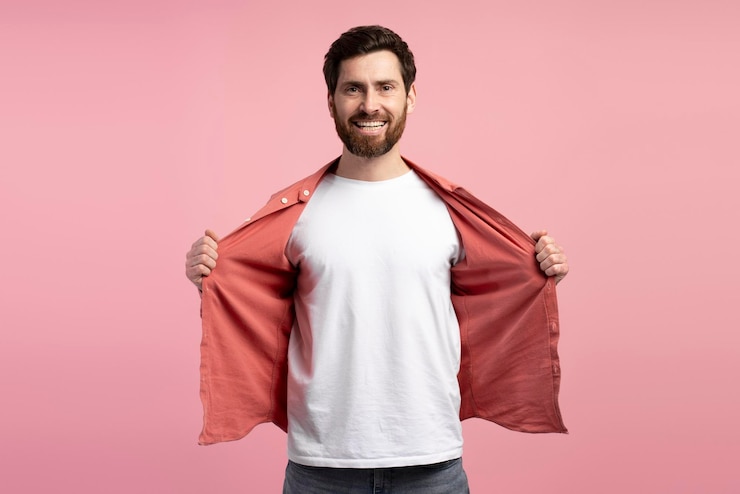Foto ein glücklicher bärtiger mann zeigt sein weißes t-shirt mit kopierraum-eröffnungshemd