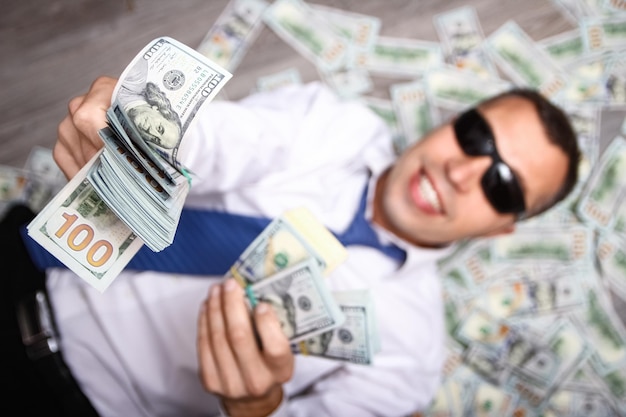 Ein glücklicher Kerl mit Geld in den Händen für die Entwicklung des Einkaufsgeschäfts und eine tolle Reise