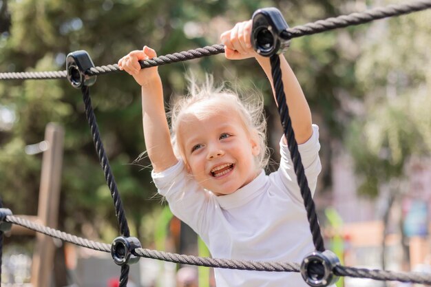 ein glücklicher kleiner blonder Junge spielt an einem Sommertag in einer Kinderstadt