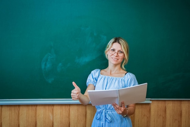 Ein glücklicher Lehrer an der Tafel im Klassenzimmer zurück zum Unterricht