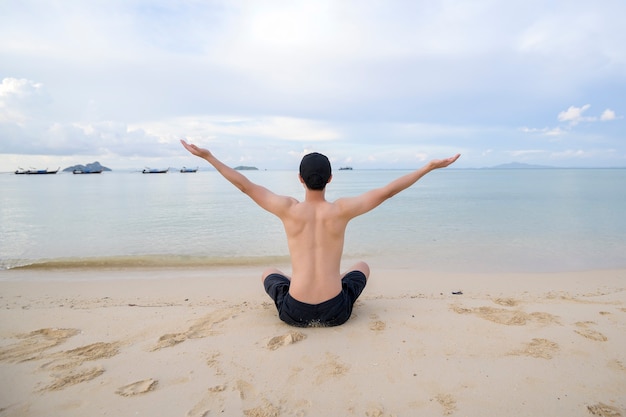 Ein glücklicher Mann, der am Strand genießt und sich entspannt