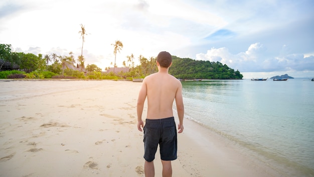 Ein glücklicher Mann, der das Strand-, Sommer- und Urlaubskonzept genießt und entspannt