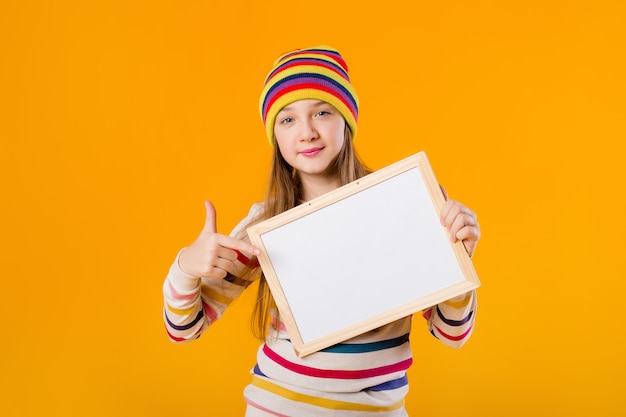 Ein glücklicher Teenager hält in seinen Händen ein leeres Zeichenbrett. Platz für Text