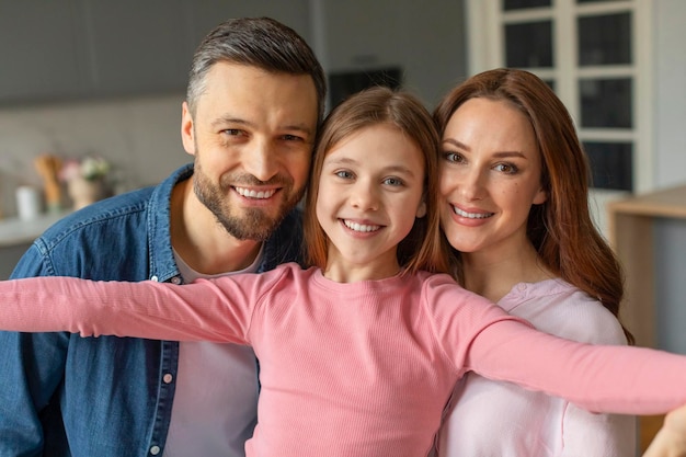 Ein glückliches Familienporträt mit einer jungen Tochter zu Hause