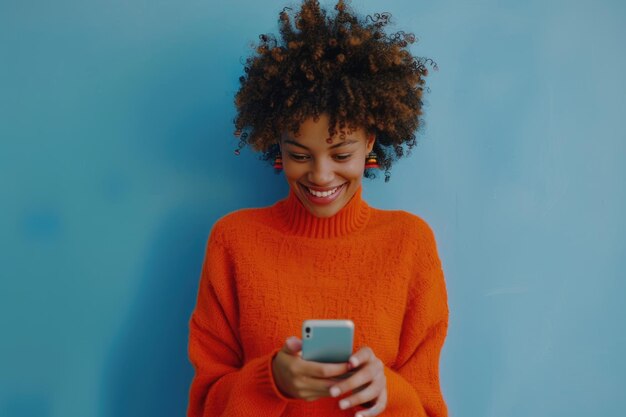 Ein glückliches Hipster-Mädchen mit Afro-Frisur, das auf dem Handy sms't.