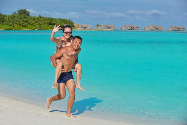 ein glückliches junges asiatisches Paar hat Spaß und romantische Zeit im Sommer am wunderschönen weißen Sandstrand