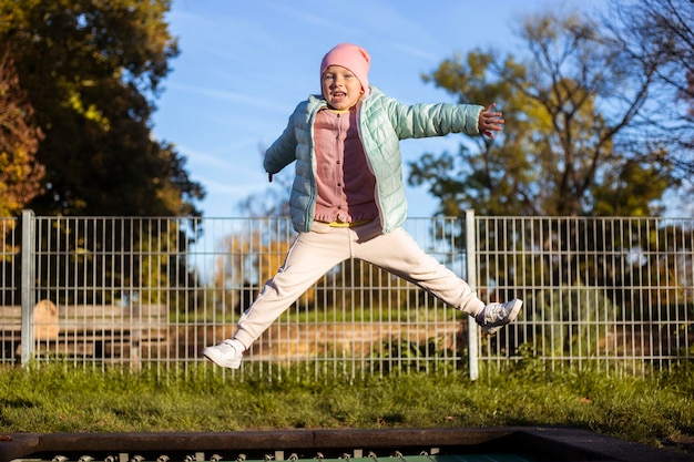 Ein glückliches kleines Mädchen springt auf einem Trampolin auf der Straße