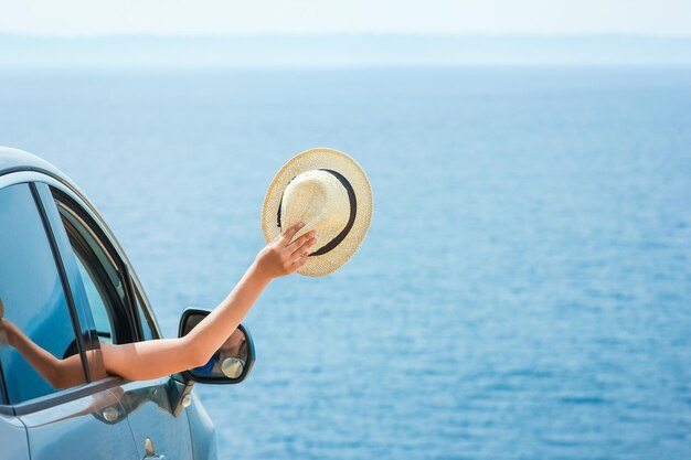 Ein glückliches Mädchen aus dem Auto am Meer Griechenland Hintergrund