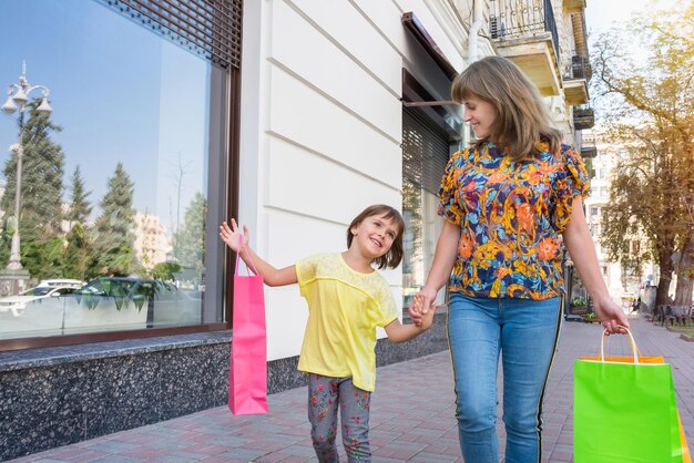 Ein glückliches Mädchen teilt die Eindrücke nach dem Einkauf in einem Geschäft mit einer Mutter