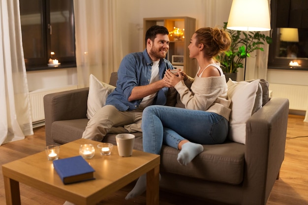 ein glückliches Paar, das abends zu Hause eine Tasse hält